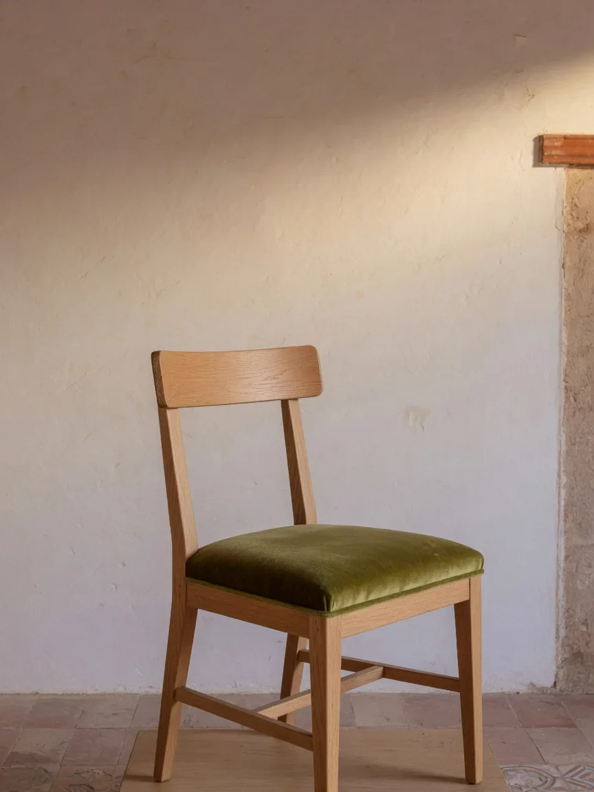 Timber dining chair with a muted green upholstered seat